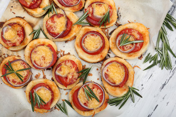 Small pizzas on baking paper close up