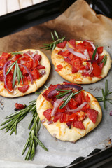 Small pizzas on baking paper close up