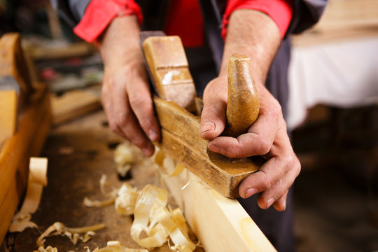 Planer at work in rugged male hands