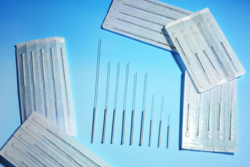 Needles for acupuncture on blue background