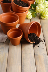 Clay flower pots and soil, on wooden table