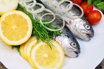 two rainbow trout with lemon and fresh vegetables
