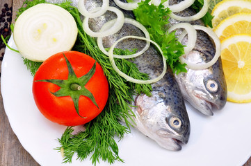 two rainbow trout with lemon and fresh vegetables