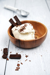 ice cream, topped with chocolate in a wooden bowl