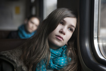 Fototapeta na wymiar teenager girl sitting in the carriage looking through the window
