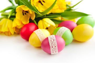 Easter eggs with tulips on white background