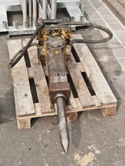 Ein kleiner Baggermeissel liegt auf einer Palette