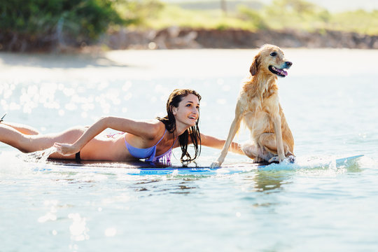 Young Woman Surfing with Her Dog - Powered by Adobe