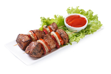 shish kebab from pork with vegetables and sauce isolated