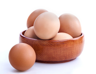 Healthy domestic eggs in a wooden bowl on a white background