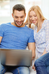 smiling happy couple with laptop at home