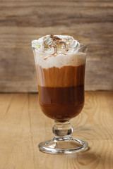 Irish coffee and stack of cookies on wooden table