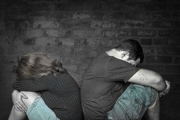 Young couple angry at each other sitting back to back