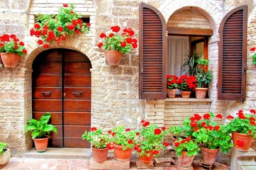 Fototapeta premium Włoski dom przód z kolorowymi doniczkowymi kwiatami