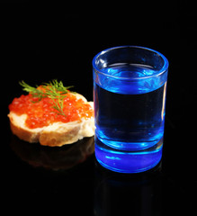 Sandwich with caviar and vodka isolated on black
