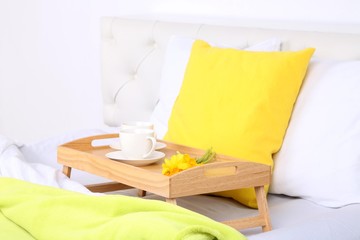 Fototapeta na wymiar Filiżanek kawy na wygodnym łóżku z miękkich poduszek