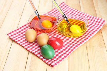 Bowls with paint for Easter eggs and eggs, close up