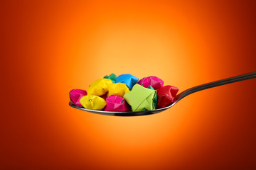 Paper stars in silver spoon on orange background