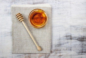 Bowl of honey on wooden table. Symbol of healthy living