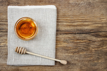 Bowl of honey on wooden table. Symbol of healthy living
