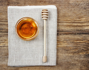 Bowl of honey on wooden table. Symbol of healthy living