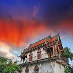 Thailand. Temple surrounded by vegetation with sunset sky on bac © jovannig