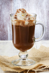 Irish coffee and stack of cookies on wooden table