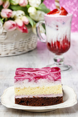 Layer cake with pink icing. Cup of strawberry milkshake decorate