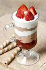 Layer strawberry and chocolate dessert in glass goblet