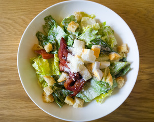  caesar salad placed on top of a wooden table