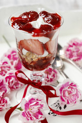 Layer strawberry and muesli dessert in glass goblet