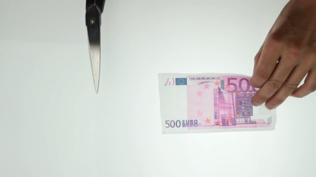 hands cutting 500 euro note