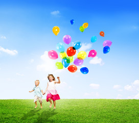 Little Girl and Boy Outdoors Holding Balloons