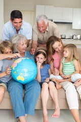 Fototapeta na wymiar Family exploring globe in living room