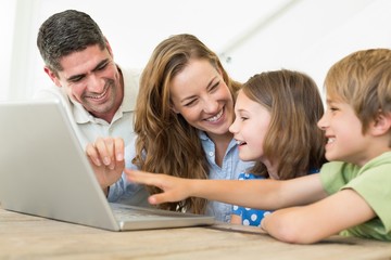 Fototapeta na wymiar Cheerful family using laptop