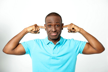 Young man covering his ears