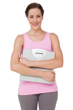 Portrait of a smiling young woman with weight scale