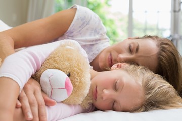 Obraz na płótnie Canvas Girl and mother sleeping peacefully with stuffed toy