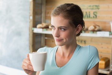 Thoughtful woman drinking coffee in coffee shop