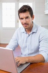 Smiling young man using laptop