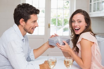 Young man giving a happy woman gift box