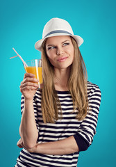 Pretty girl in hat standing with juice thinking of vacation