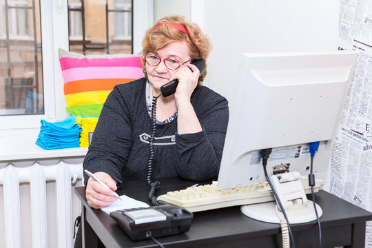 Senior Caucasian woman calling on telephone in office