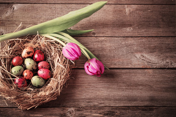 Fototapeta na wymiar Easter egg nest with flowers on rustic wooden background