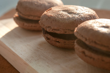 Chocolate flavor Macaroon placed on wood and leather