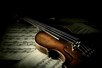 Old scratched violin in shadow
