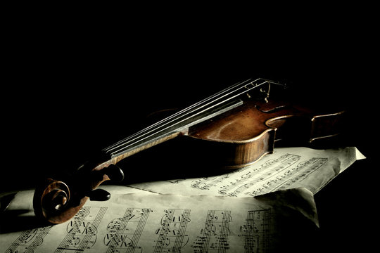 Old scratched violin in shadow