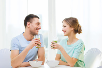 Obraz na płótnie Canvas smiling couple having breakfast at home