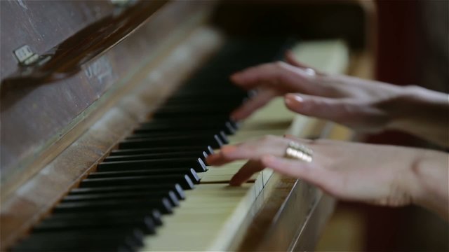 Female hands playing the piano (close-up)