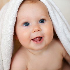 A beautiful smiling baby wrapped in quilt